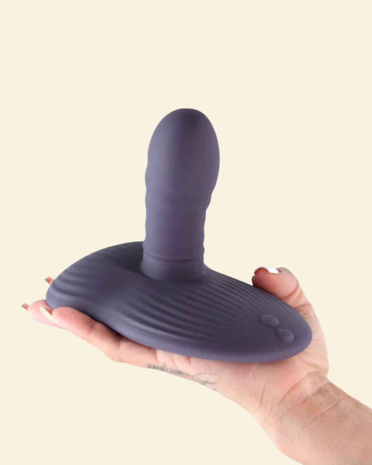 Purple thrusting and grinding vibrating pad held on a hand on a beige back ground
