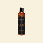 Bottle of Intimate Earth massage oil on a beige background
