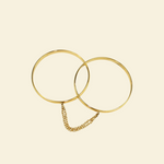 Gold bangle handcuffs beige background