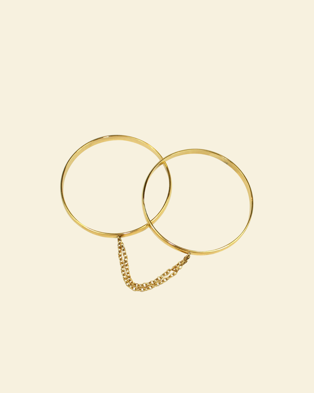 Gold bangle handcuffs beige background