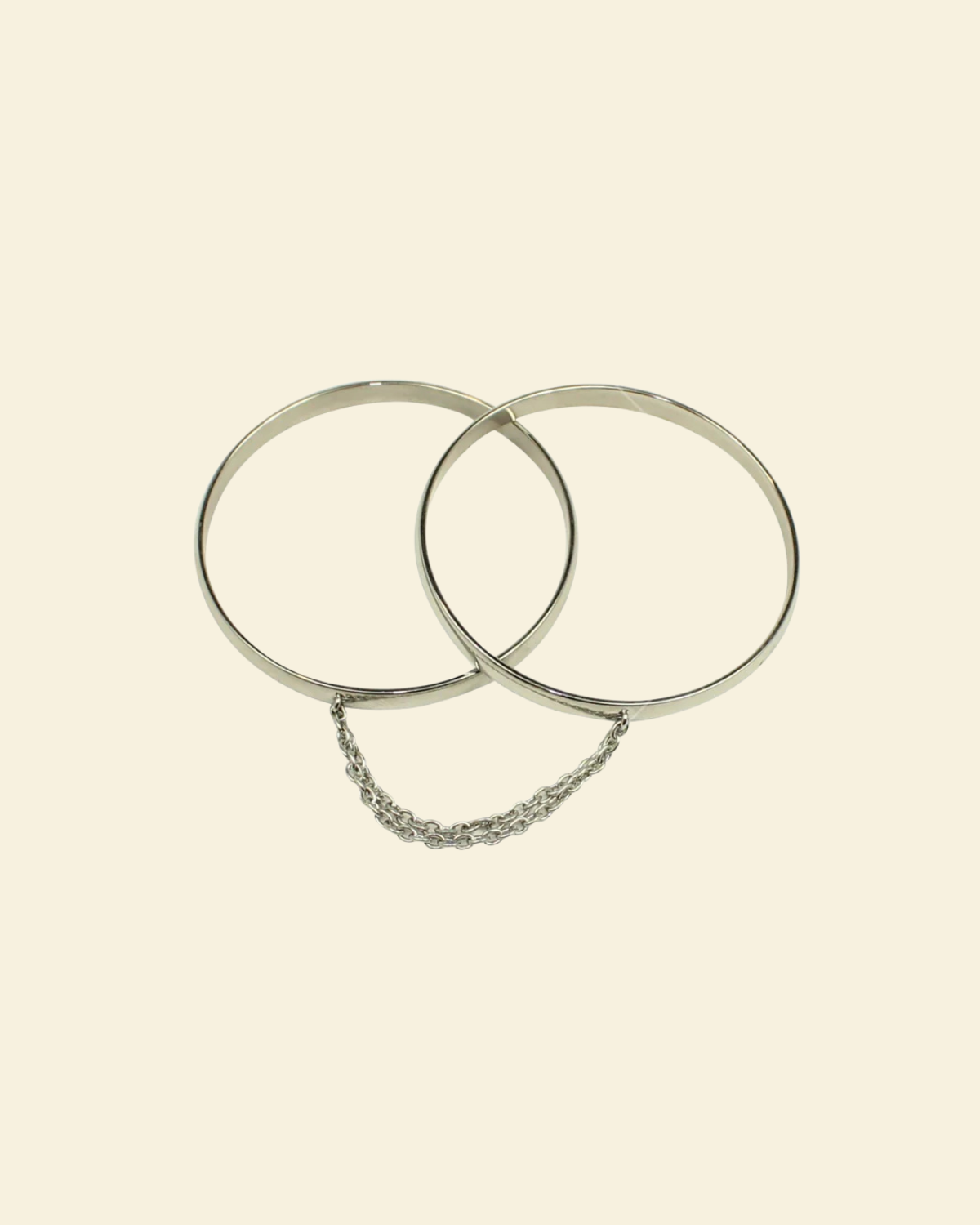 Two silver hoop earrings on a beige background