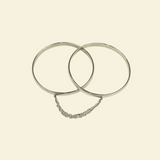 Two silver hoop earrings on a beige background