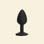 Black silicone butt plug on a beige background