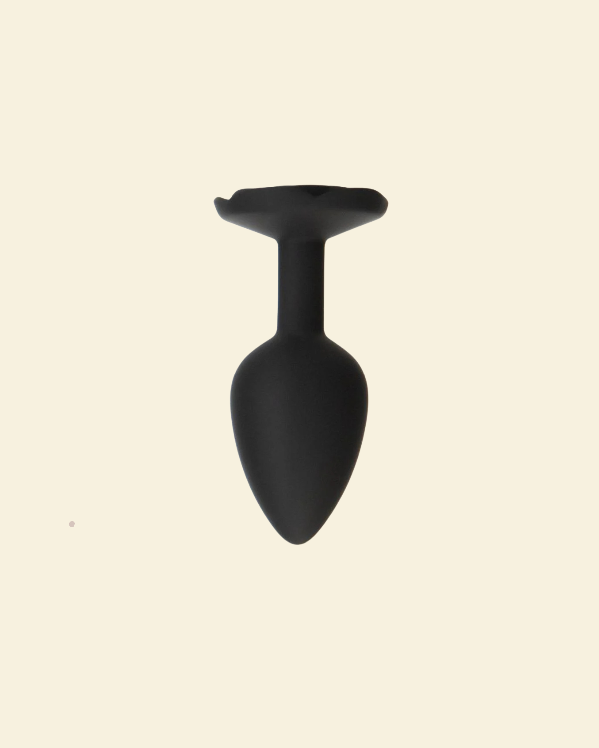 Black silicone butt plug on a beige background
