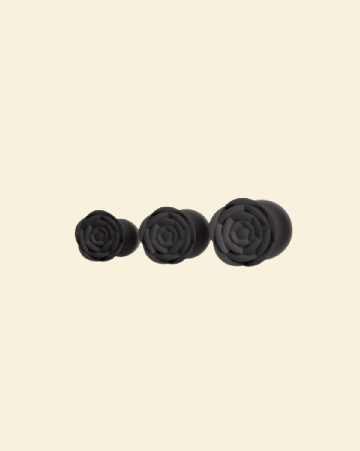 the rose bases of 3 black silicone buttplugs in different sizes