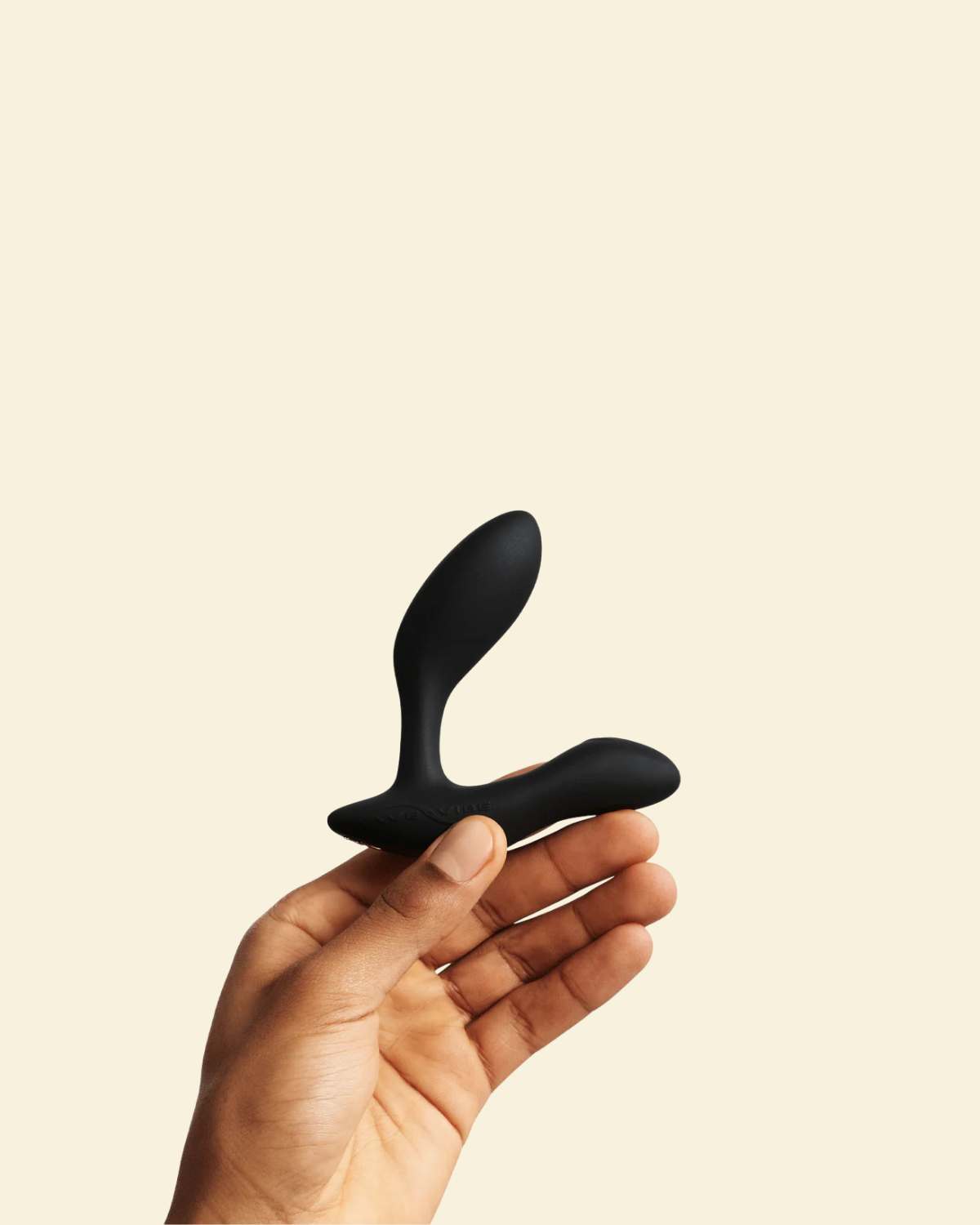 Hand holding black vibrating butt plug