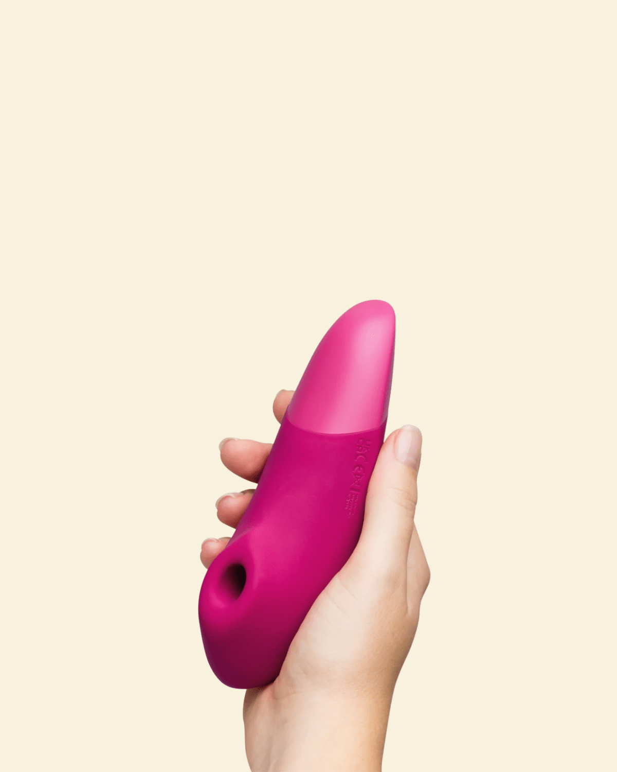 Hand holding a pink Womanizer Enhance