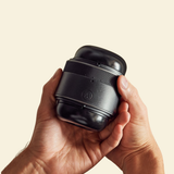 2 hands holding a black adjustable non-vibrating stroker 