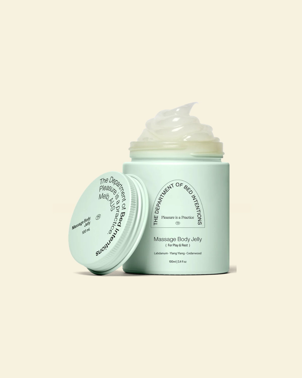 A mint green jar of massage body jelly with its lid leaning against it, showing a dollop of pale yellowish-green jelly on top. The text on the jar reads 'The Department of Sex Education' and 'Massage Body Jelly'.