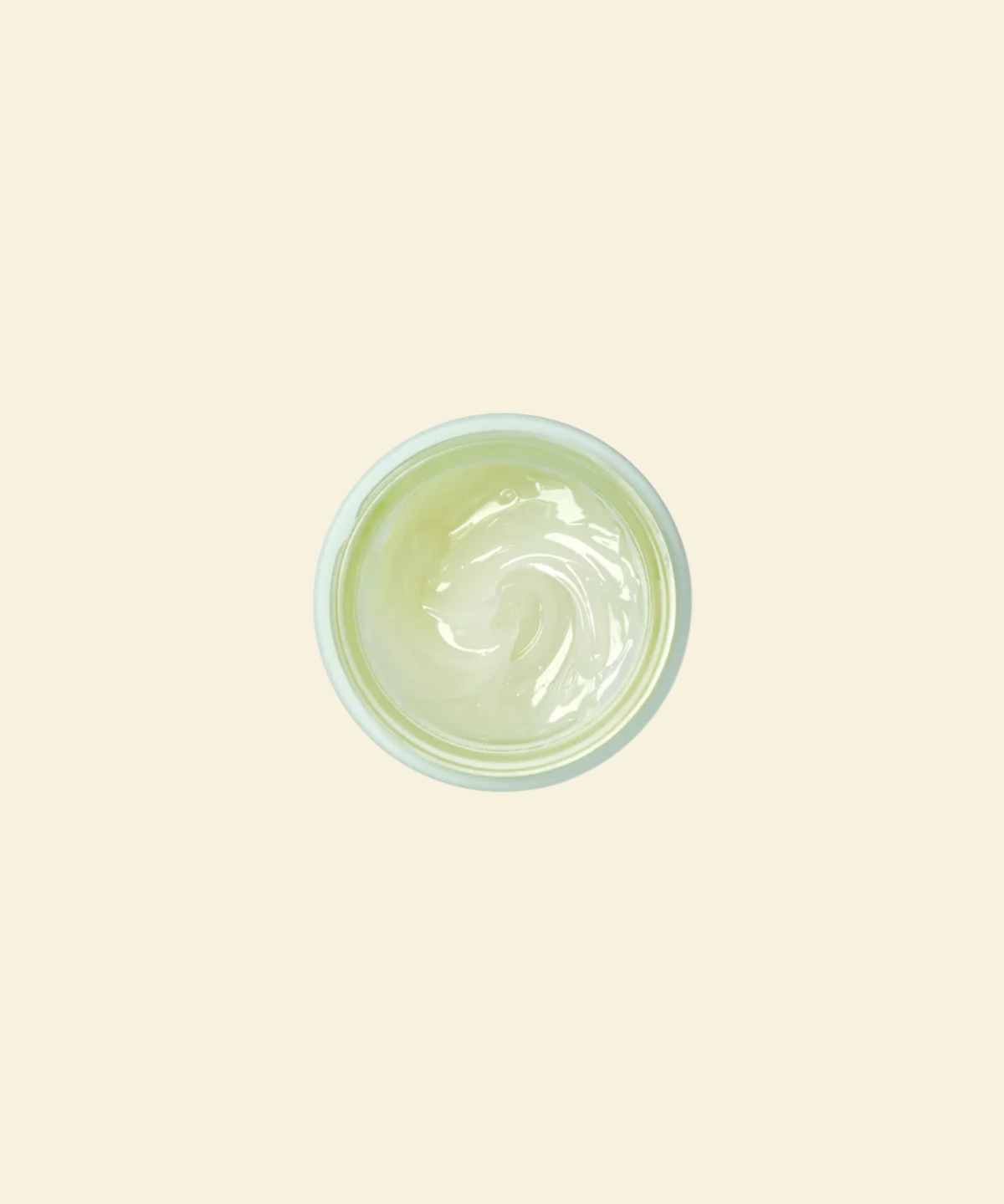 A top-down view of a small round container filled with a pale yellow-green cream or gel, centered on a solid light beige background.