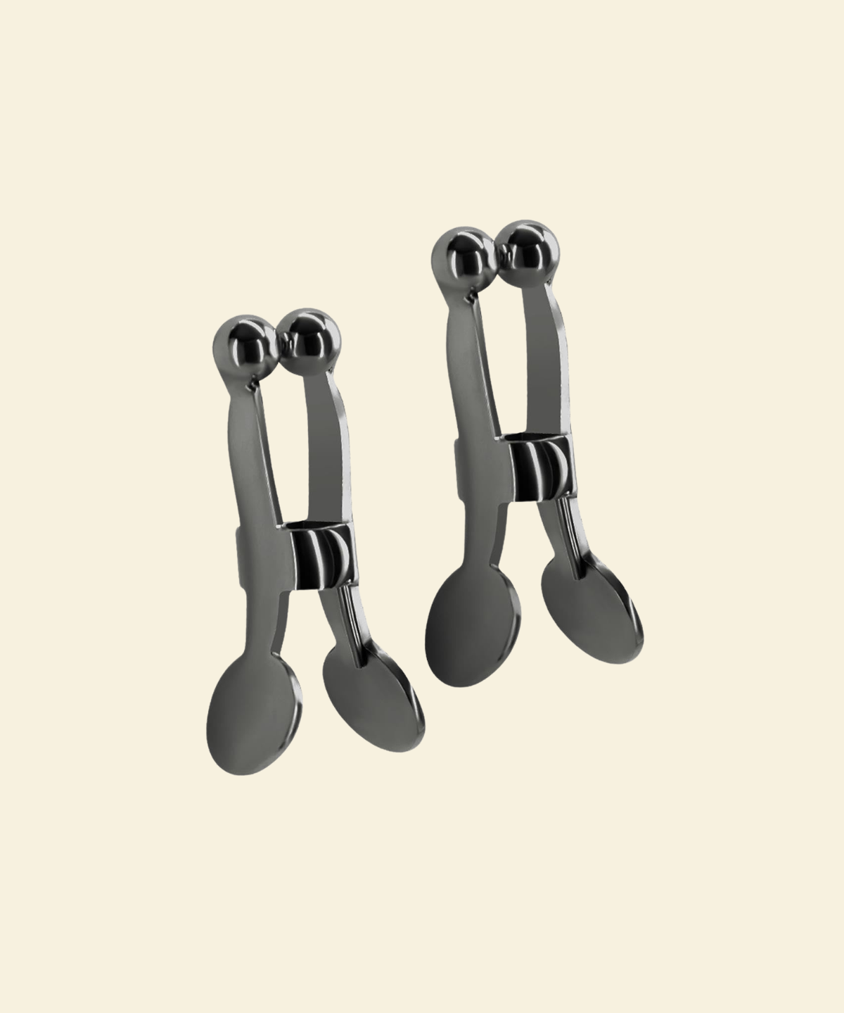 Set of gun metal nipple clamps on a beige background