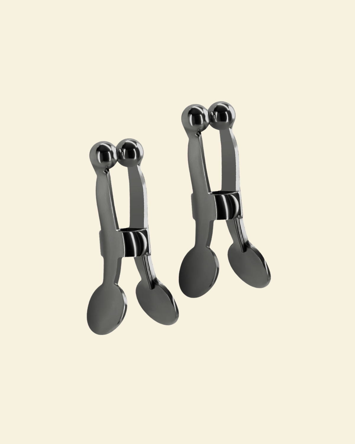 Set of gun metal nipple clamps on a beige background