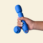 Hand holding a blue silicone toy against a beige background