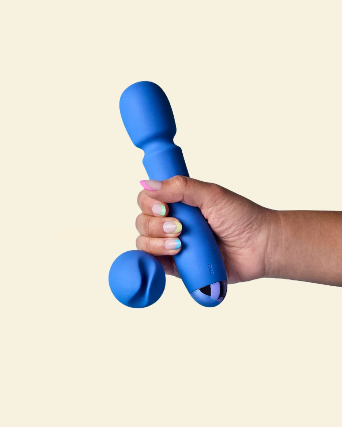 Hand holding a blue silicone toy against a beige background