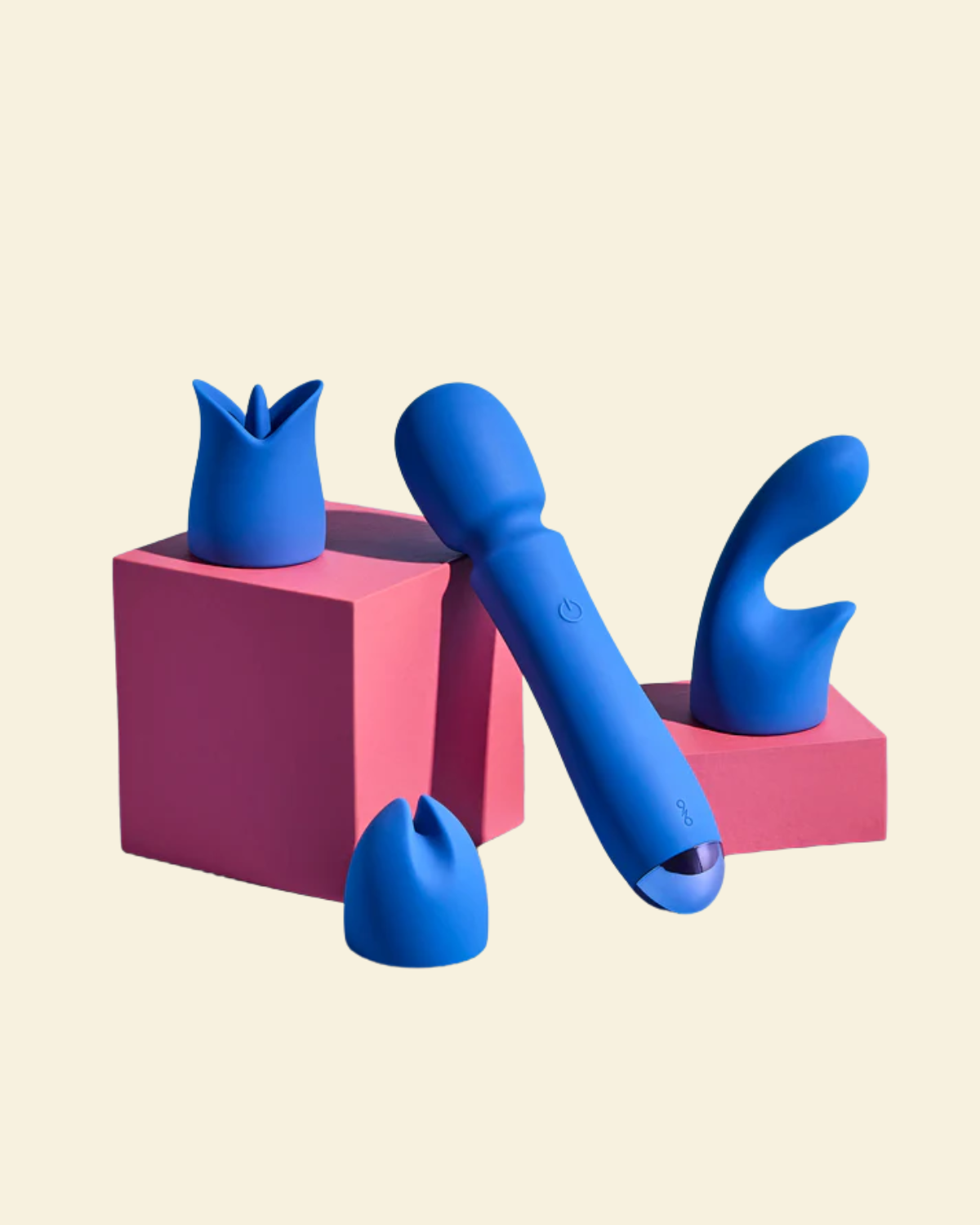 Blue silicone wand vibrator on pink blocks against a beige background