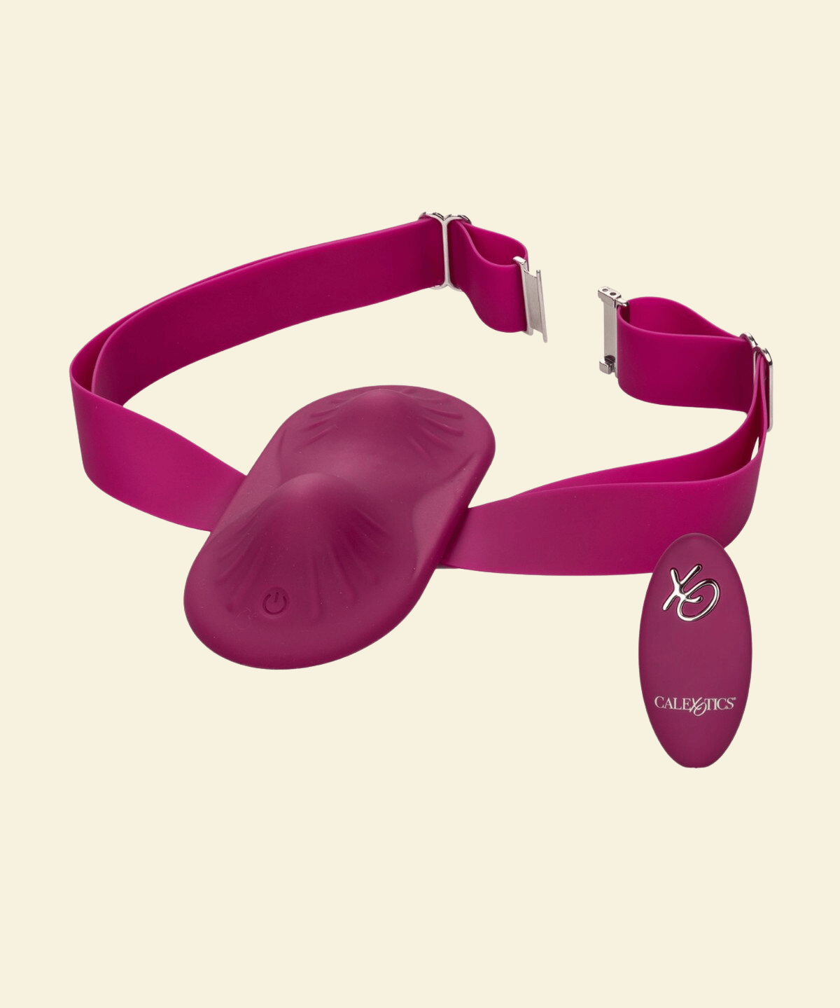 A magenta pink wearable vibrator with an adjustable strap and a matching oval-shaped remote control, displayed on a solid cream background.