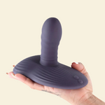 Purple thrusting and grinding vibrating pad held on a hand on a beige back ground