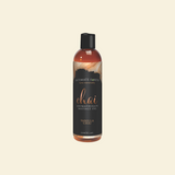 Bottle of Intimate Earth Chai Fragrance Massage Oil on a beige background