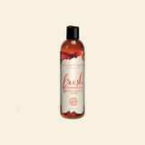 Bottle of intimate lubricant with strawberry flavor on a beige background