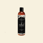 Bottle of Intimate Earth Naked Fragrance Free Personal Lubricant on a beige background