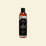 Bottle of Intimate Earth Naked Fragrance Free Personal Lubricant on a beige background