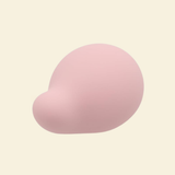 A soft pink palm vibrator on a beige background
