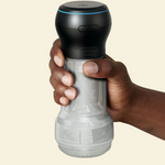 Black and clear suction and stroking masturbator held by a hand