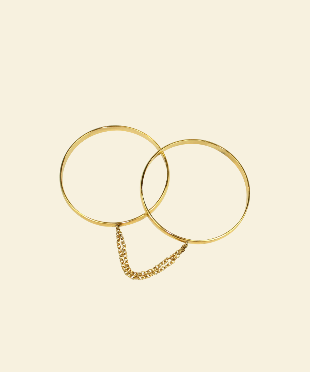 Gold bangle handcuffs beige background