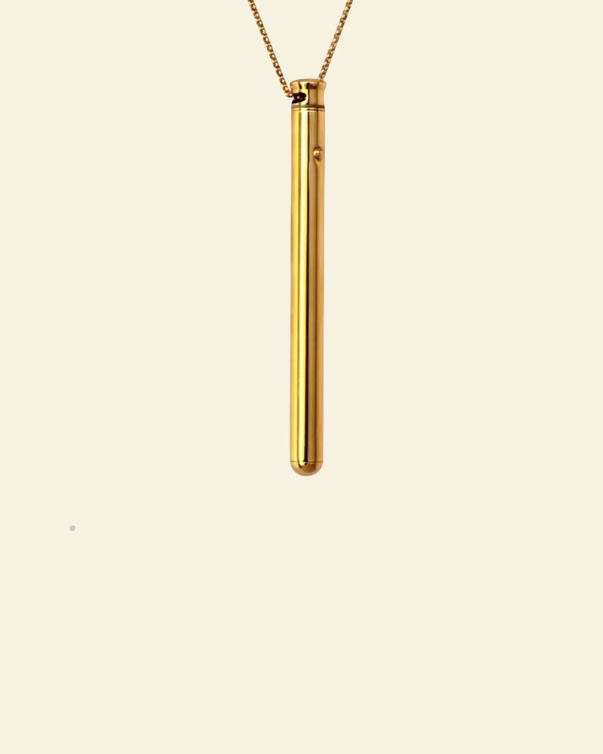 A gold plated vibrating necklace on beige background