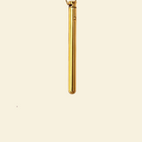 A gold plated vibrating necklace on beige background