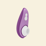 Purple Womanizer Air suction toy on beige background