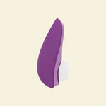 Purple Womanizer Air suction toy on beige background - side view