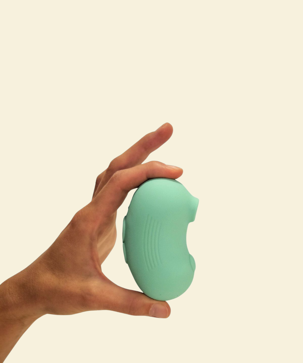 A hand holding a mint green air-suction toy