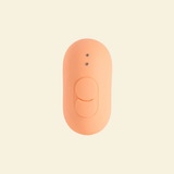 the backside of a coral colored tapping and vibrating massager, showing two buttons