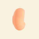 Side view of a coral colored tapping and vibrating massager 
