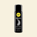 Black bottle of pjur Original lubricant on a beige background