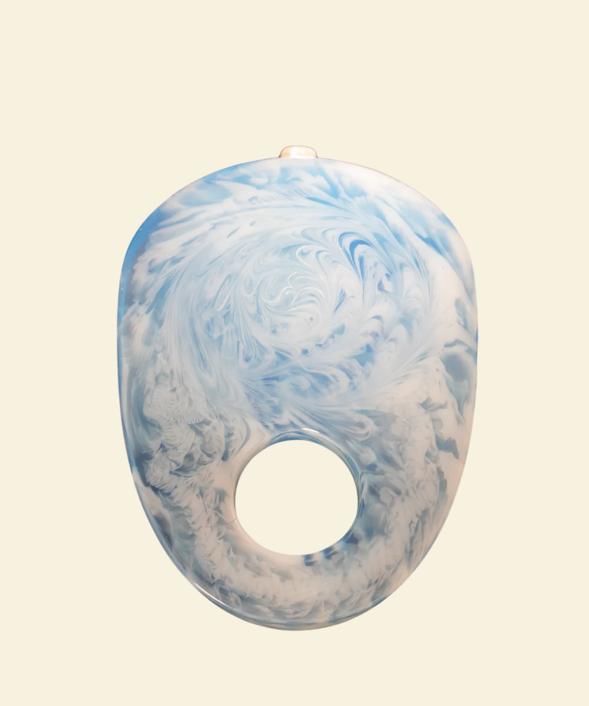 Blue and white marbled object on a beige background