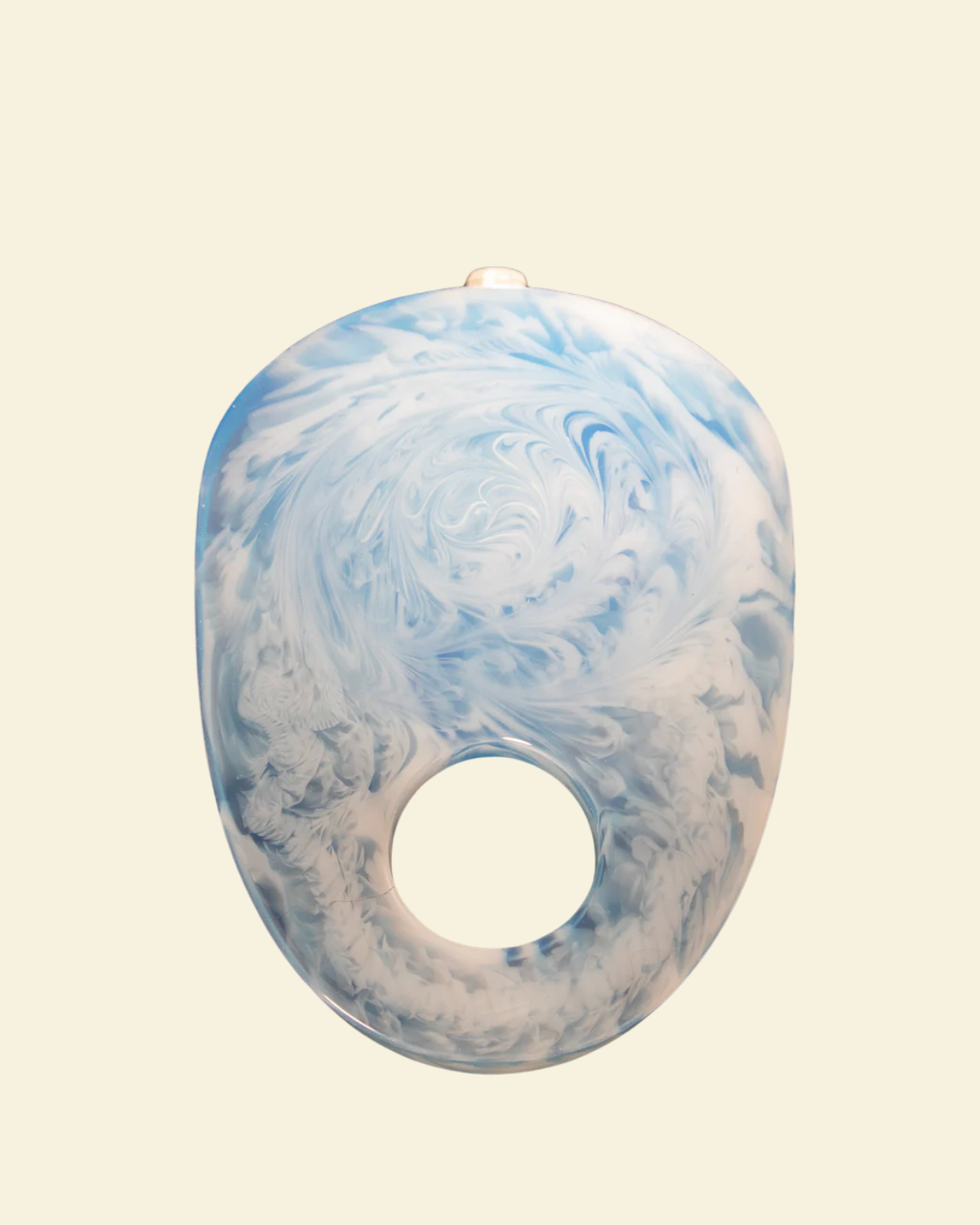 Blue and white marbled object on a beige background