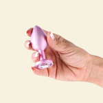 hand holding a pink butt plug