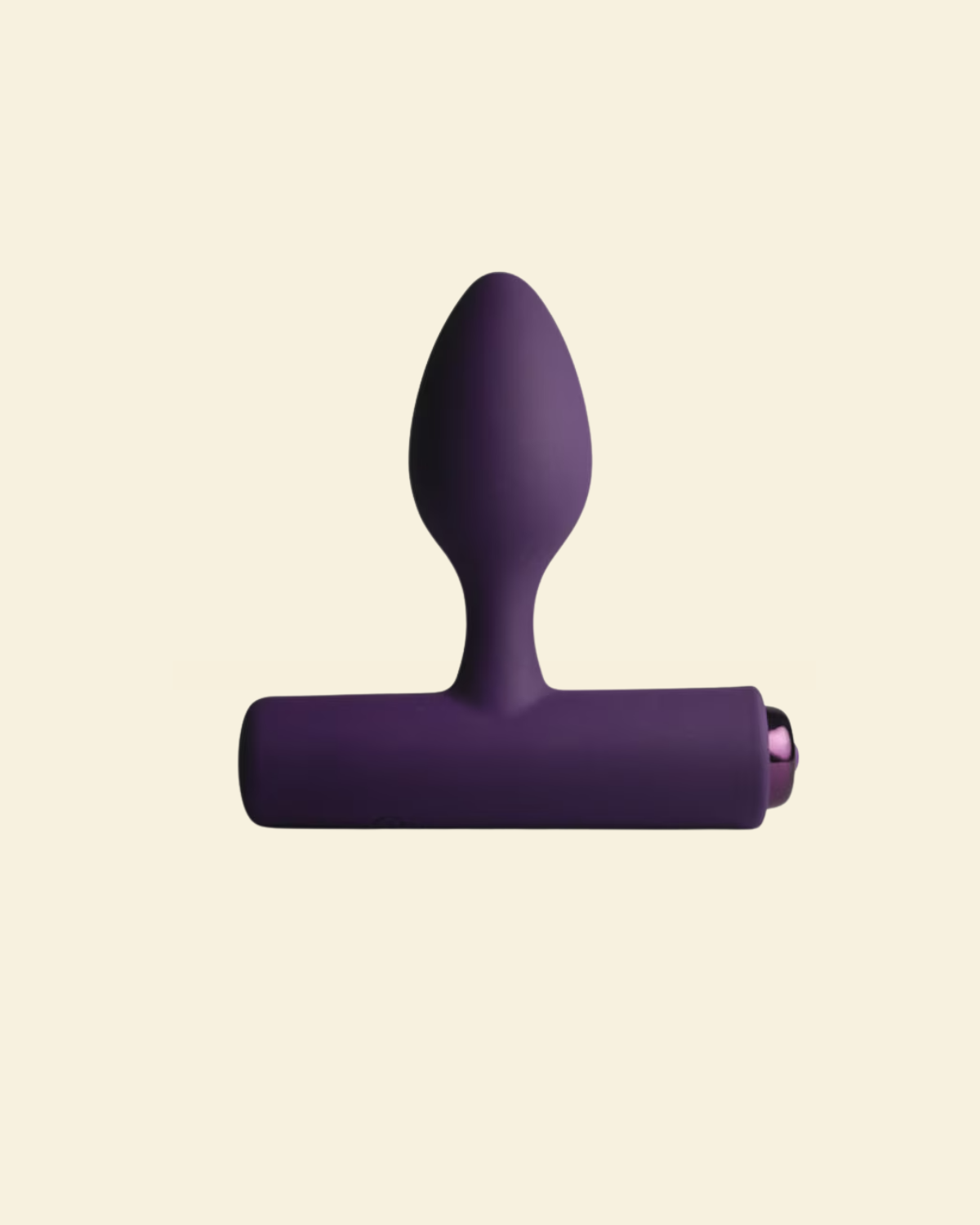Purple vibrating butt plug on beige background
