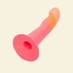 Pink and orange silicone dildo on beige background