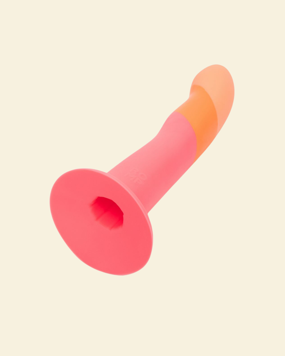 Pink and orange silicone dildo on beige background