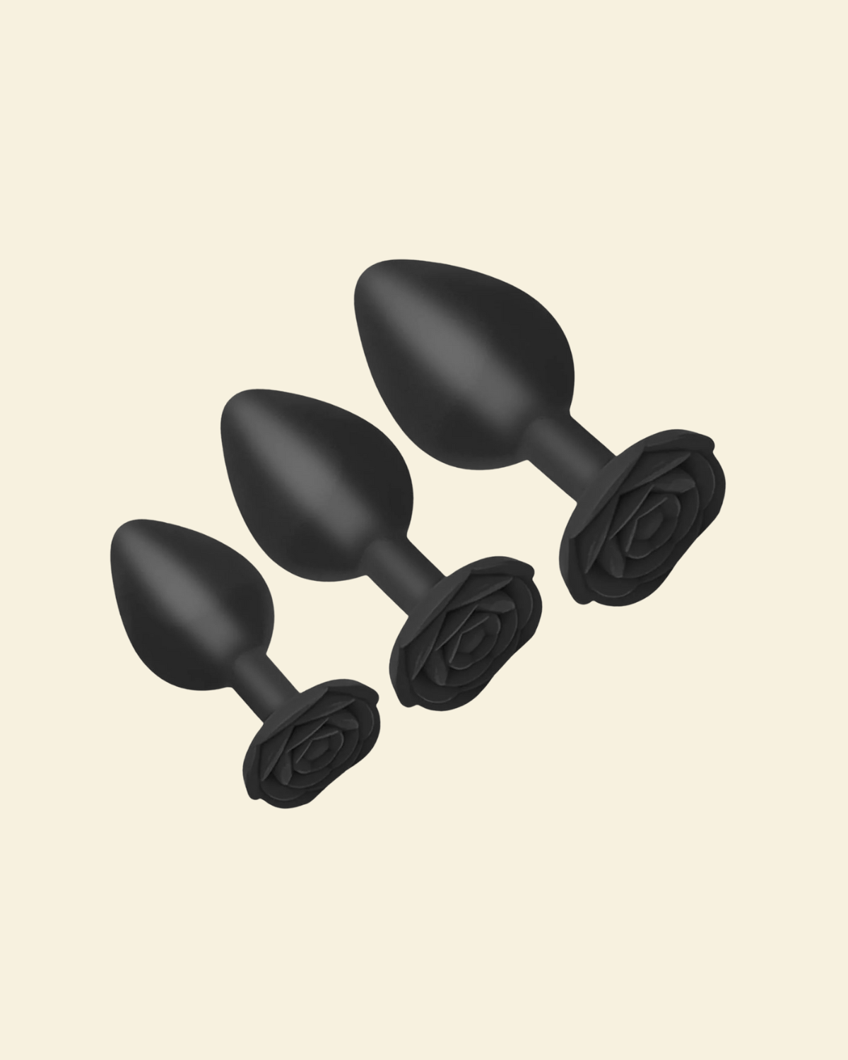 Set of black silicone butt plugs on a beige background