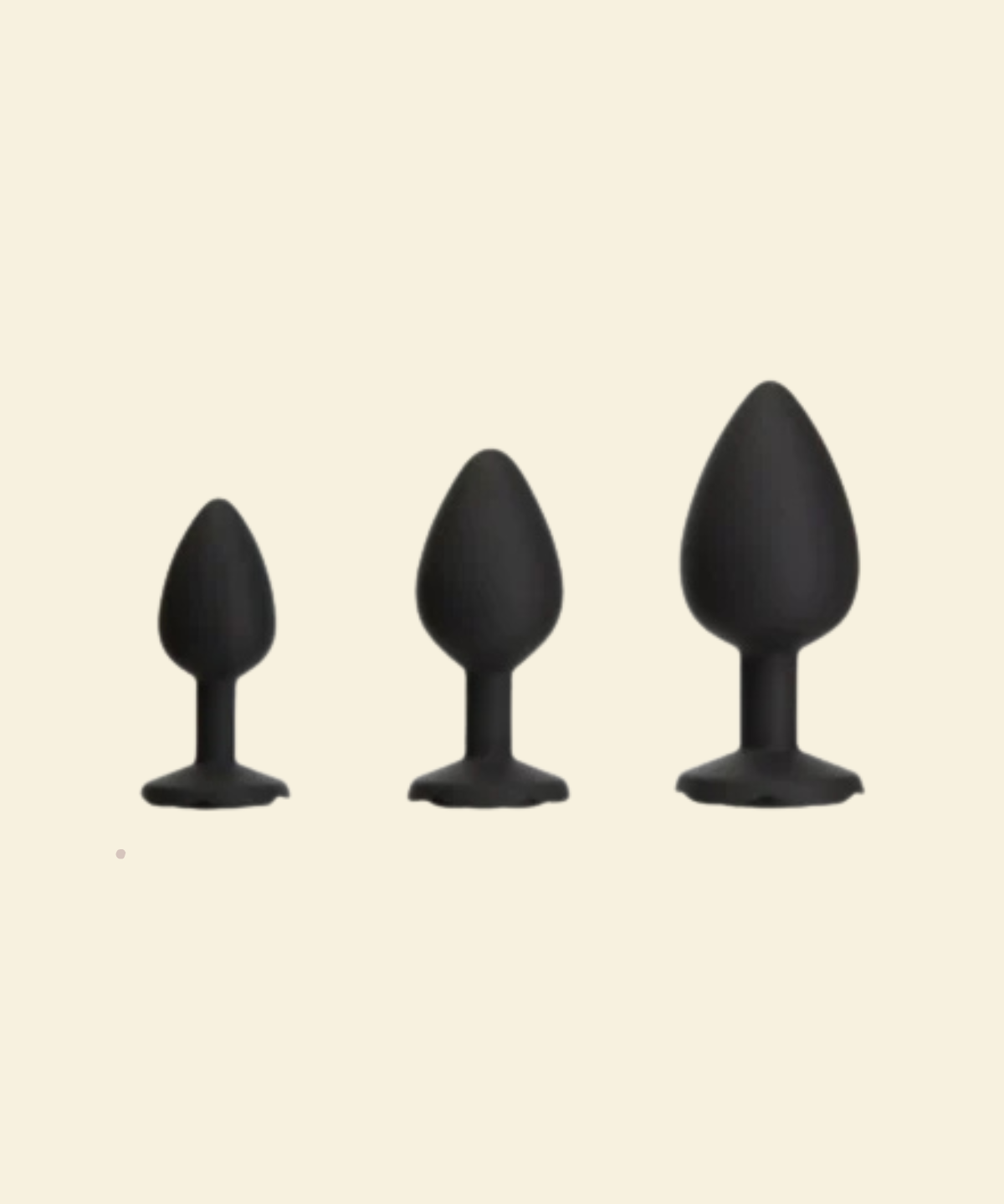 Three black silicone butt plugs of different sizes on a beige background