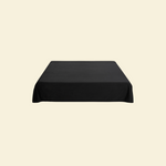 Black waterproof splash blanket laid over a bed 