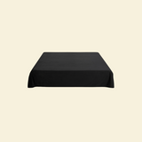 Black waterproof splash blanket laid over a bed 