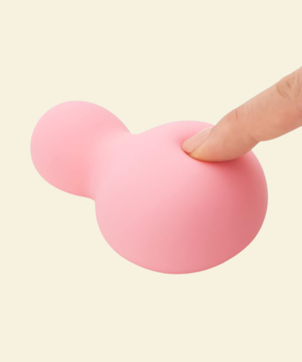 a finger softly pressing into a pink soft silicone vibrator