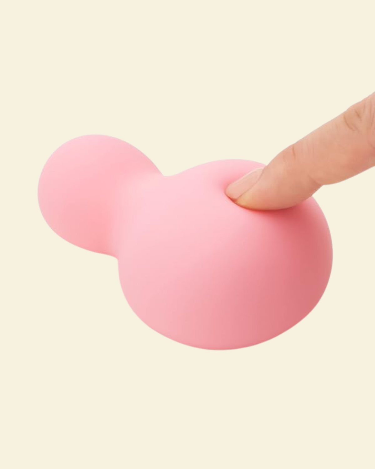 a finger softly pressing into a pink soft silicone vibrator