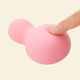 a finger softly pressing into a pink soft silicone vibrator