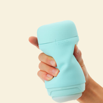 A hand holding a mint green reusable stroker 